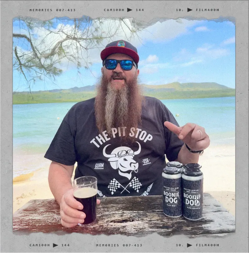 Carabao Brewing owner and head brewer Ben with Boonie Dog cans on the beach
