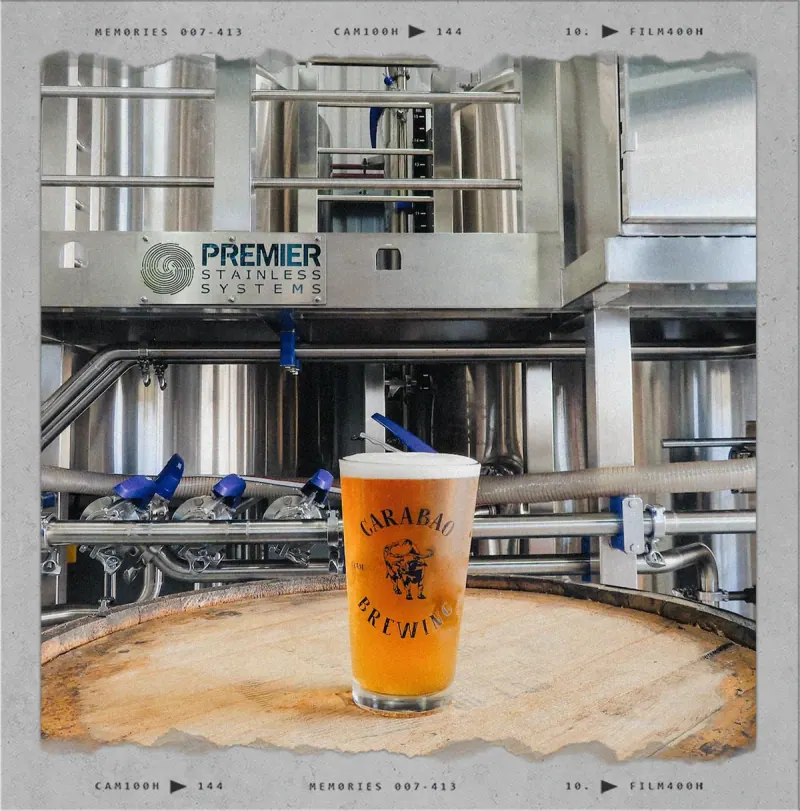 A pint of Carabao beer in front of the brewhouse tanks